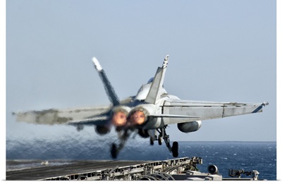 A F/A-18F Super Hornet launches from the flight deck of aircraft carrier USS Nimitz