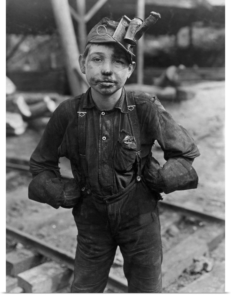 A filthy young coal miner after a long day of work in the mines of West Virginia.