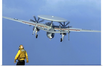 A Flight Deck Director Watches An E-2C Hawkeye Taking Off