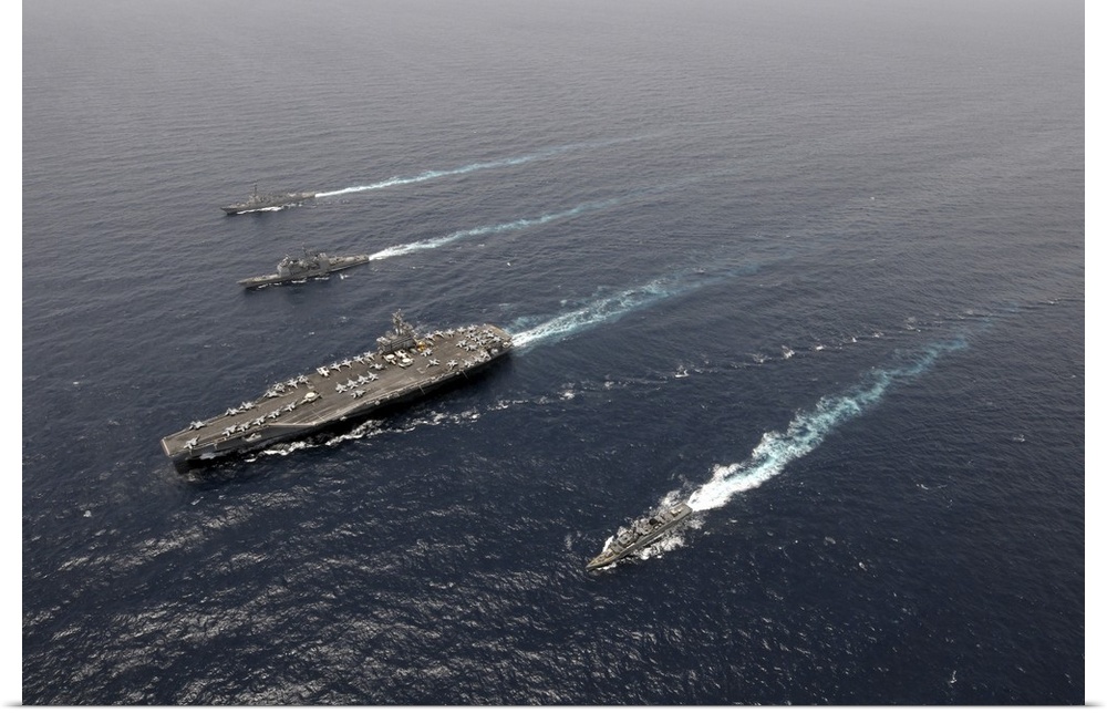 A formation of ships traveling at sea.