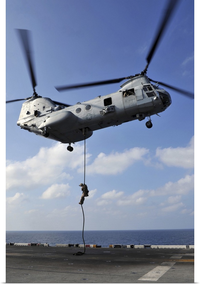 Arabian Sea, January 12, 2012 - A Marine fast ropes from a CH-46E Sea Knight helicopter onto the flight deck of the amphib...