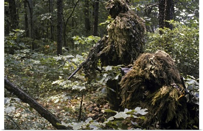 A Marine sniper team wearing camouflage ghillie suits