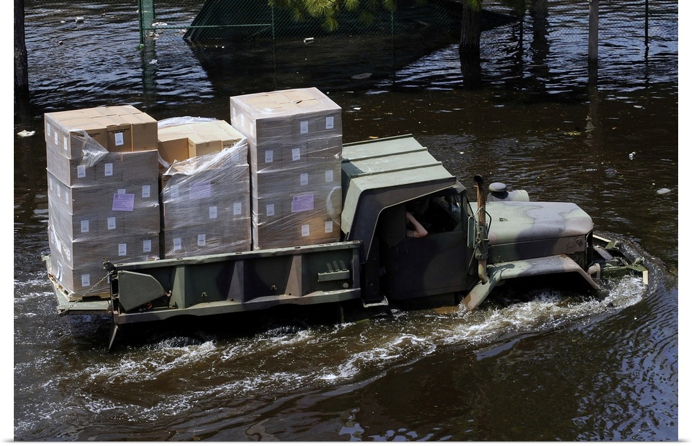 A National Guard M817 5-ton Dump Truck fords the floodwaters left by Hurricane Katrina to take supplies to the Super Dome ...