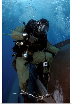 A Navy SEAL climbs aboard a SEAL Delivery vehicle before launching from a submarine
