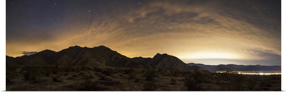 A partly coiudy sky over Borrego Springs reflects lights from the surrounding desert cities in California.