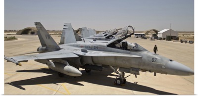 A row of U.S. Marine Corps F-18 Hornets await post-flight maintenance