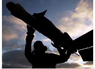 A Sailor inspects a Captive Air Training Missile attached to an F/A18F Super Hornet