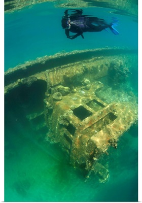 A snorkeler swims above a shipwreck in Palau's inner lagoon