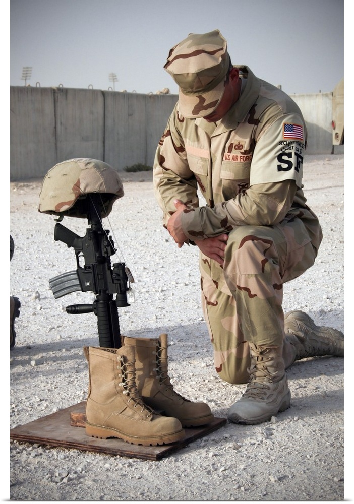 A soldier bows to pay tribute to a fallen soldier.