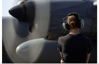 A soldier monitors the performance of a newly repaired C130 Hercules engine