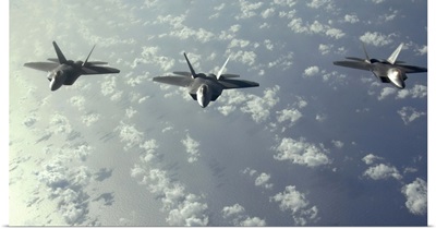 A threeship formation of F22 Raptors fly over the Pacific Ocean
