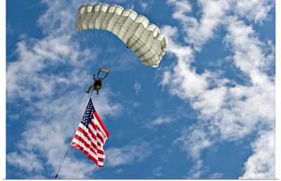 A U.S. Air Force member glides through the sky with the American flag
