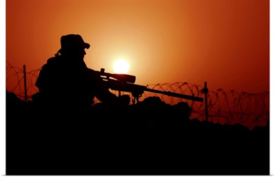 A U.S. Special Forces soldier armed with a Mk-12 Sniper Rifle at sunset