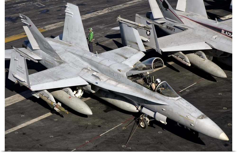 A US Navy F/A-18C Hornet parked on the flight deck of aircraft carrier USS Nimitz.