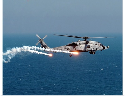 A US Navy HH-60H Seahawk Helicopter Dispenses Flares And Chaff