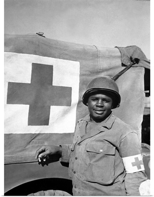 A World War II soldier stands next to his Red Cross vehicle