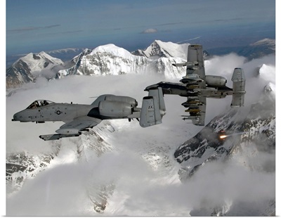A10 Thunderbolt IIs fly over mountainous landscape