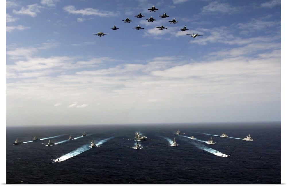 Aircraft fly over a group of U.S. and Japanese Maritime Self-Defense Force ships.