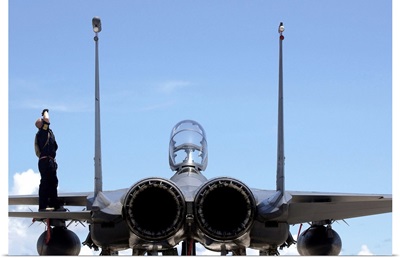 Airman checks an F-15E Strike Eagle for airframe damage