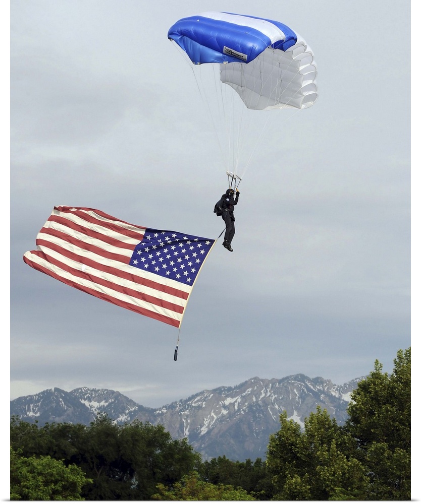 Airman floats through the sky carrying the American flag.