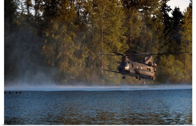 Airmen wait in a lake for an MH-47 Chinook helicopter to extract them