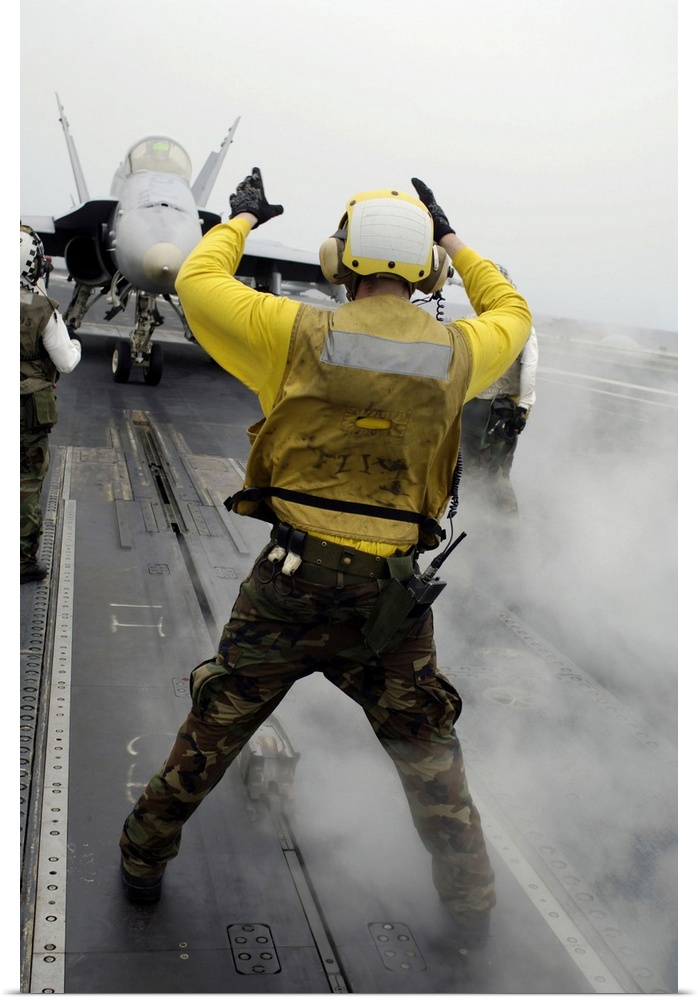 Pacific Ocean, April 16, 2008 - An aircraft director signals an F/A-18C Hornet from taxi to launching position on the flig...