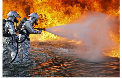 An aircraft rescue firefighting team attempts to spray out a fuel fire