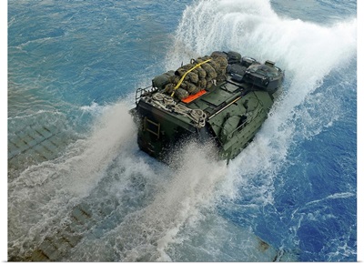 An amphibious assault vehicle exits the well deck of USS Fort McHenry