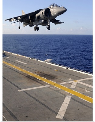 An AV-8B Harrier jet prepares to land on the flight deck of USS Essex