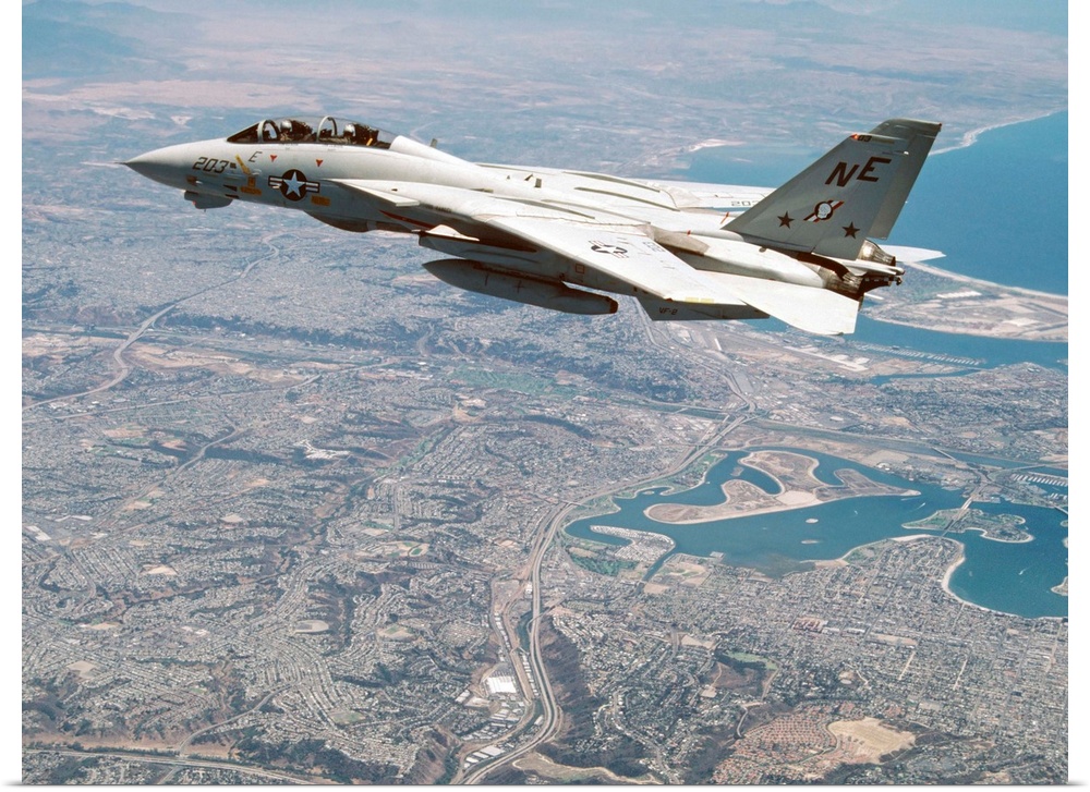 An F-14A Tomcat of U.S. Navy Fighter Squadron 2 (VF-2, the Bounty Hunters) cruises above San Diego after a training flight...