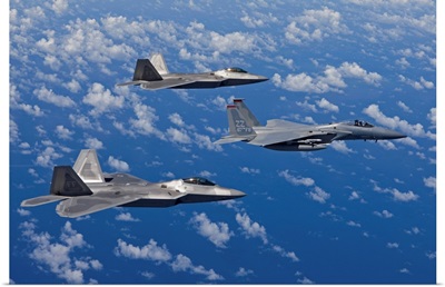 An F-15 Eagle and two F-22 Raptors fly in formation over Japan