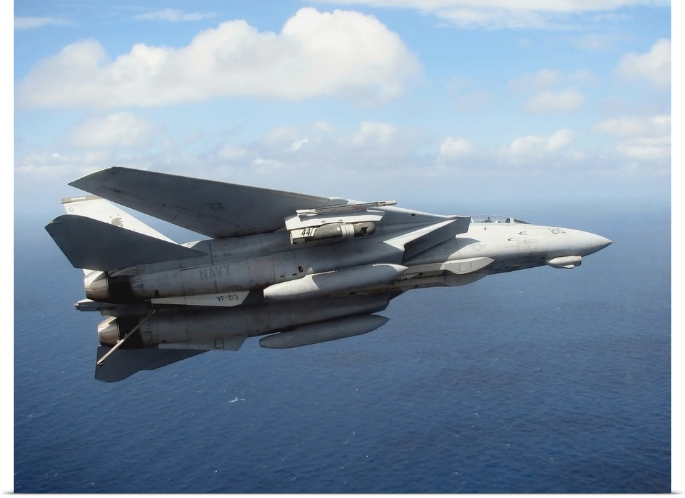 An F14D Tomcat banks with its tailhook lowered in preparation for landing