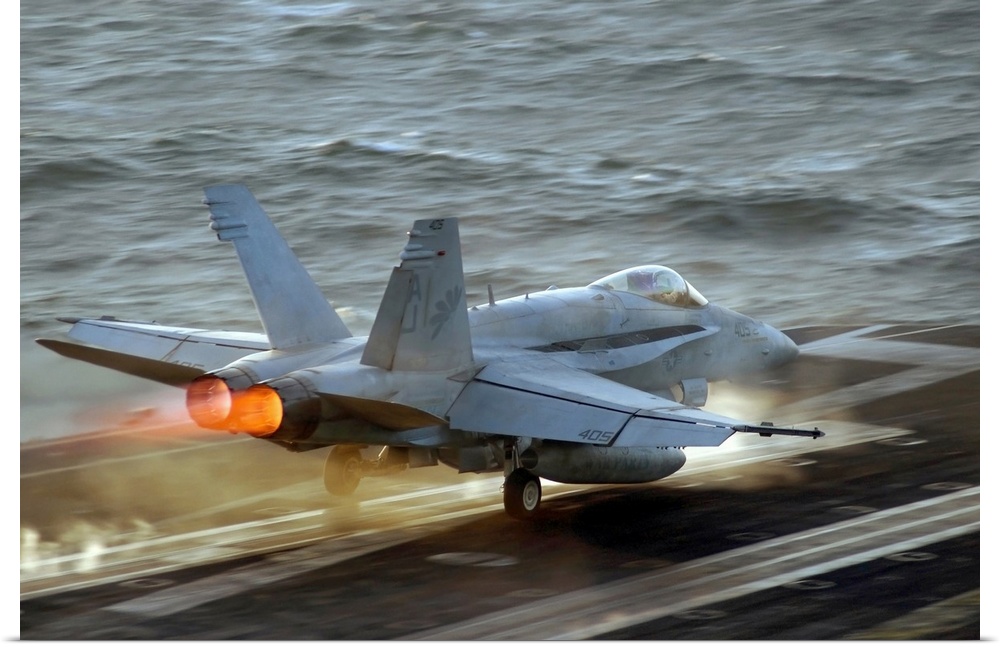 Up-close photograph of jet taking off of an air craft carrier in the ocean.