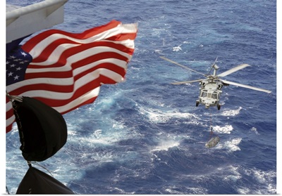 An MH-60S Sea Hawk carries supplies during a replenishment at sea
