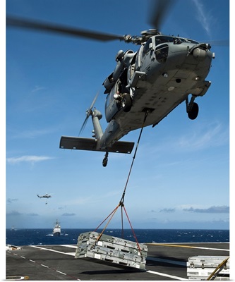 An MH-60S Sea Hawk Helicopter Lowers Cargo Onto The Deck Of USS John C Stennis