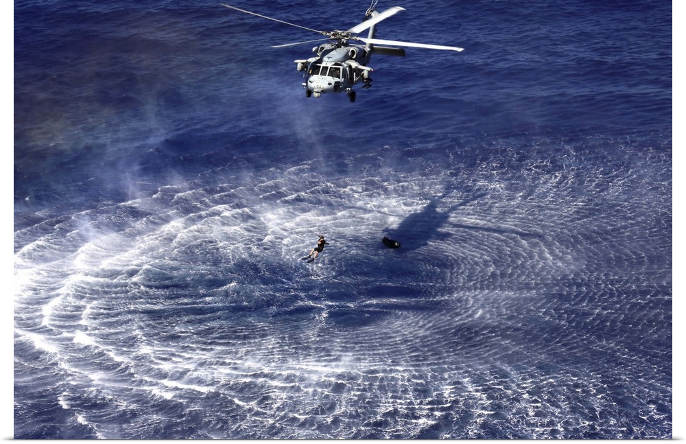 December 11, 2013 - An MH-60S Seahawk lowers a rescue swimmer into the water as part of a simulated combat search and resc...