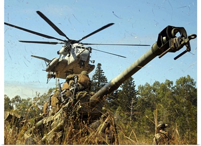 An MH53E Sea Stallion helicopter preparing to lift an M777 105mm lightweight Howitzer