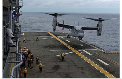 An MV-22 Osprey tiltrotor aircraft prepares to land on the flight deck