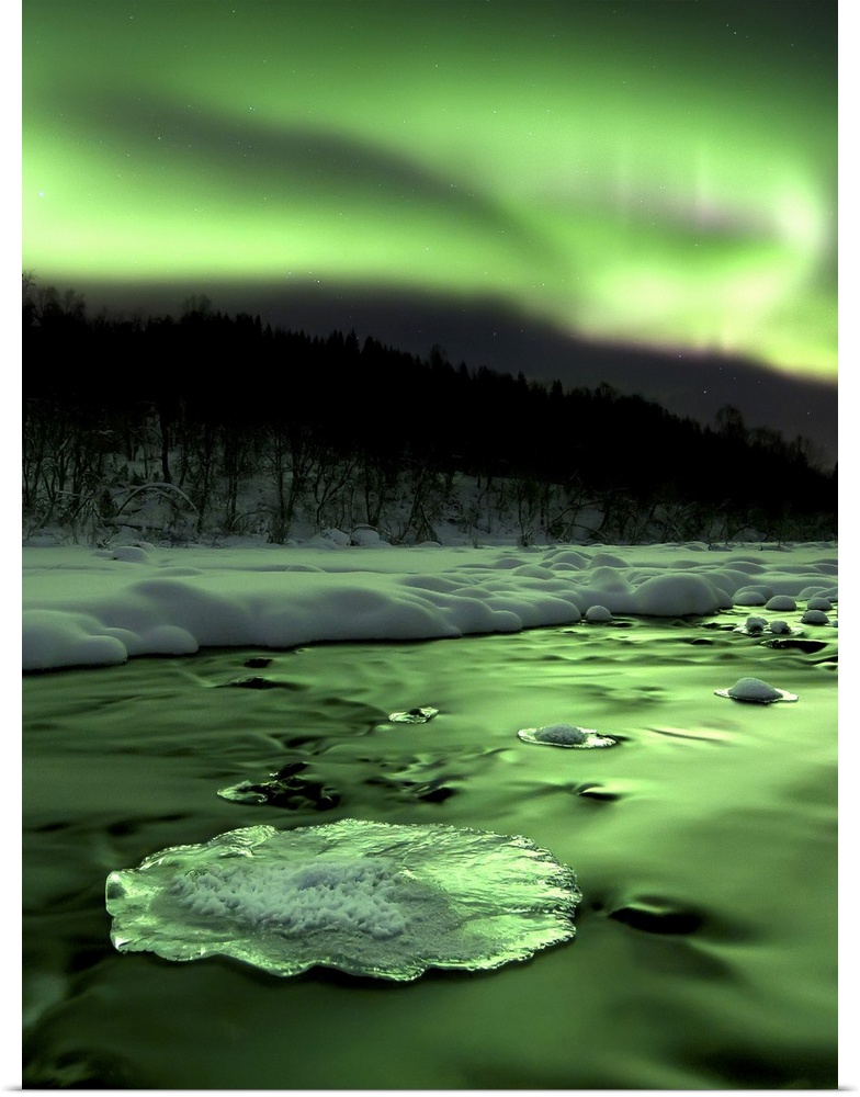Aurora Borealis reflects off the Tennevik River, Troms County, Norway. Auroras are the result of the emissions of photons ...