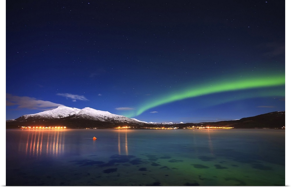 Aurora over Tjeldsundet and Saetertinden Mountain in Troms County, Norway. Auroras are the result of the emissions of phot...