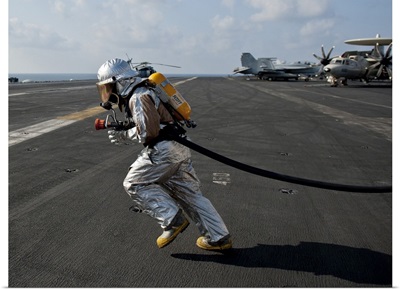 Aviation Boatswain'S Mate Carries A Fire Hose During A Fire Drill