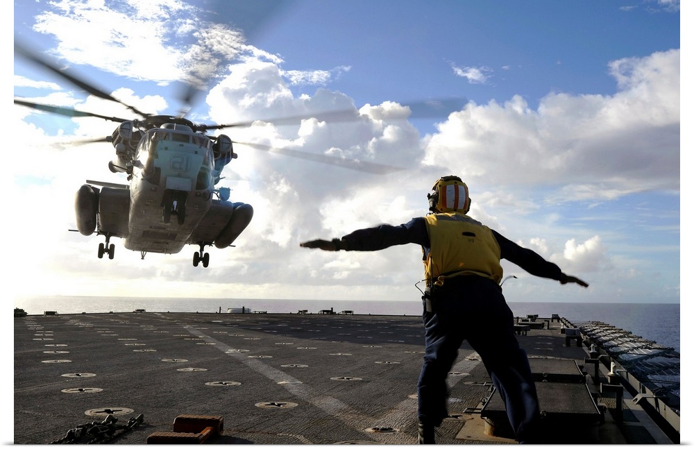 East China Sea, September 11, 2010 - Aviation Boatswain's Mate directs a CH-53E Super Stallion helicopter aboard the amphi...