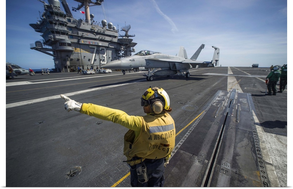 Philippine Sea, August 22, 2013 - Aviation Boatswain's Mate directs an F/A-18E Super Hornet on the flight deck of the airc...