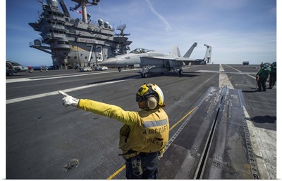 Aviation Boatswain's Mate directs an F/A-18E Super Hornet