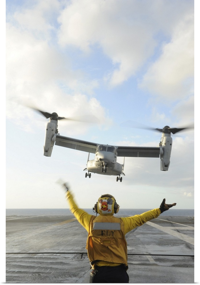 Atlantic Ocean, February 5, 2012 - Aviation Boatswain's Mate signals an MV-22 Osprey to land on the flight deck of the air...
