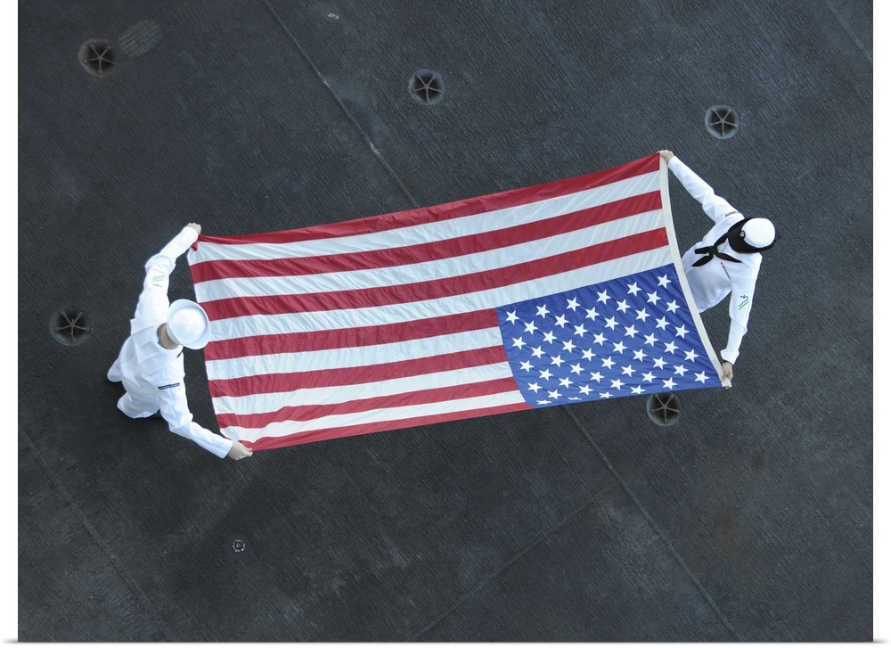 November 17, 2015 - Aviation Ordnancemen fold the American flag aboard USS Theodore Roosevelt after departing Joint Base P...