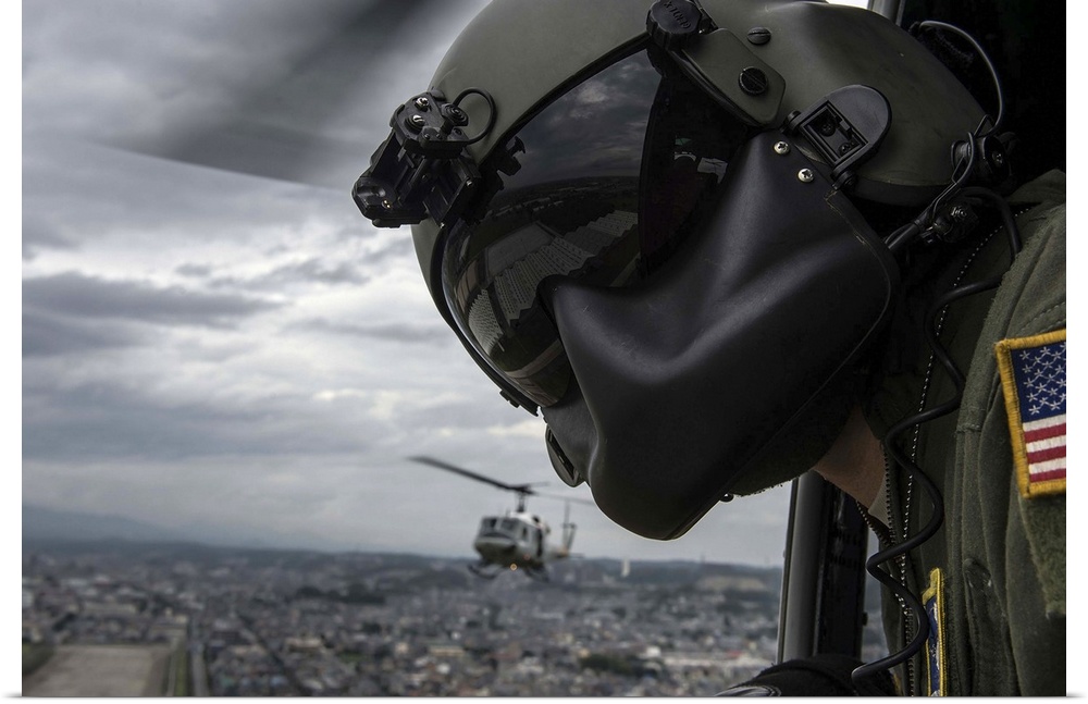 August 12, 2014 - Crew chief scans the area for potential obstacles, from a UH-1N Huey helicopter during a training missio...