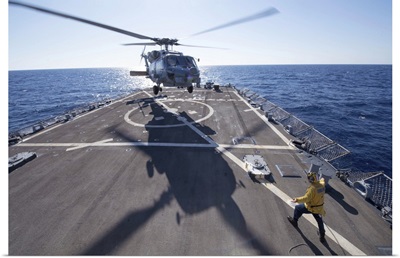 Cryptologic Technician directs an SH-60R Sea Hawk helicopter