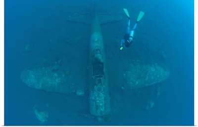 Diver explores the wreck of a Mitsubishi Zero fighter plane
