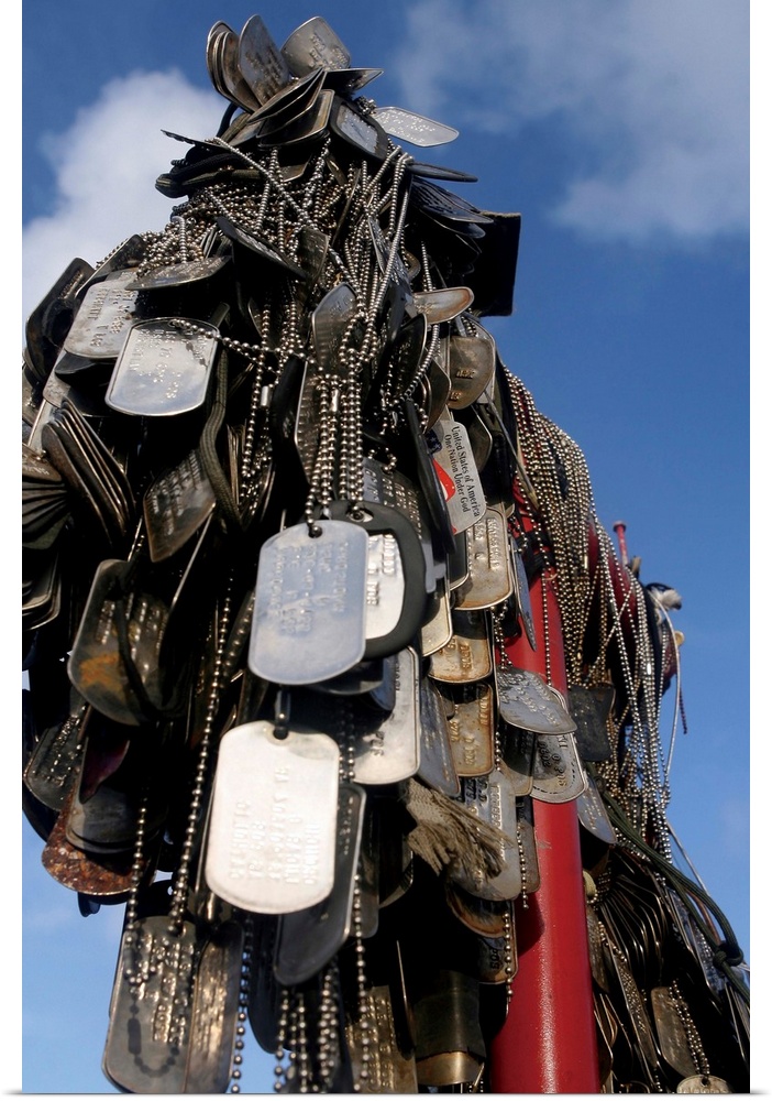 Dog tags from Marines and sailors who have visited Iwo Jima hang in front of the 5th Marine Division memorial at the site ...